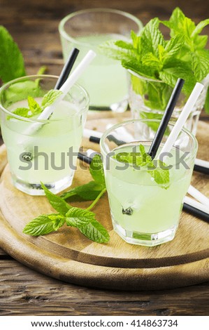 Green sweet alcohol cocktail with mint and ice, selective focus