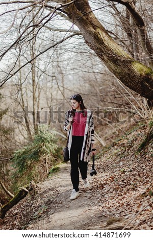 stylish hipster woman walking  with analog photo camera in woods