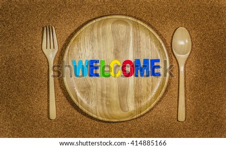 word welcome on plate with fork and spoon