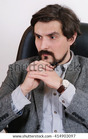 portrait of attractive serious man working at his desk at the office; business concept