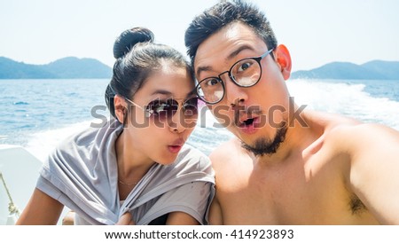 Asian couple lover is taking selfie on speedboat.