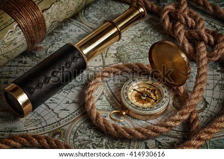 Nautical background with a navigation tools: telescope, compass and old maps Royalty-Free Stock Photo #414930616