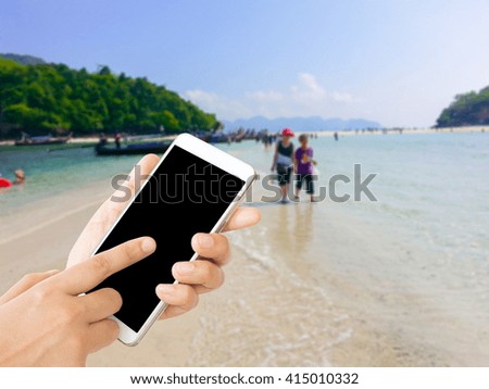 woman use mobile phone and blurred image of the beach in Krabi Thailand