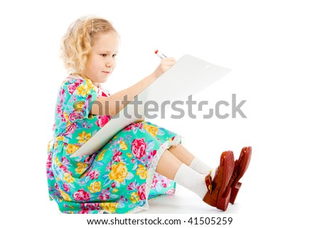 Lovely blond preschool girl drawing on a whiteboard