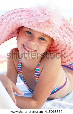 Happy cute child lying down on deckchair of beach resort 