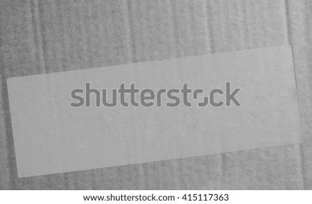 Pink paper tag or label or sticker for product information on a corrugated cardboard box packet in black and white