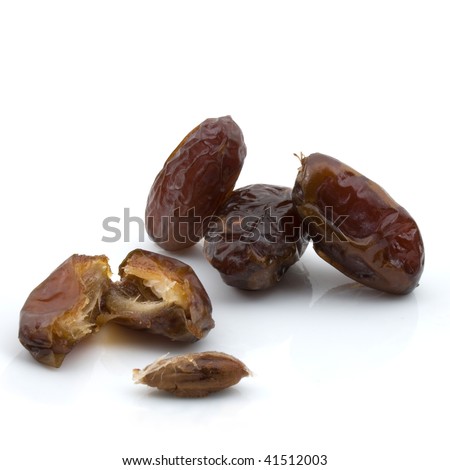 Medjool dates un-pitted - High resolution image of whole and cut fruit showing seed. Detailed skin texture and faint reflection visible on large file. Subject totally isolated on white background.
