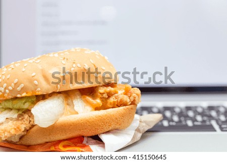 Burger on laptop in office with copy space background.