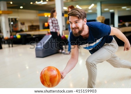 Handsome man throwing bowling ball