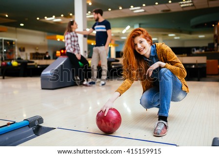 Friends enjoying competitive bowling