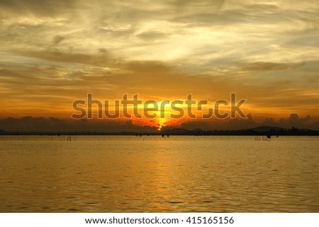 Long exposure shot over the Silhouette image the lake and downtown at Songkhla Thailand during sunset.Motion blur, soft focus due to slow shutter speed.
