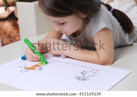 Girl in bright clothing draws a picture of the family. Light room 