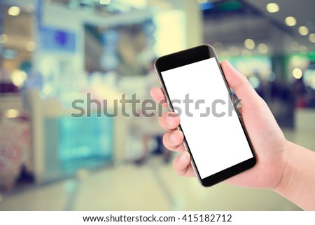Smart phone with white screen in hand on blurred in shopping mall background