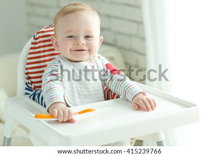 Portrait Of Happy Young Baby Boy In High Chair
 Royalty-Free Stock Photo #415239766