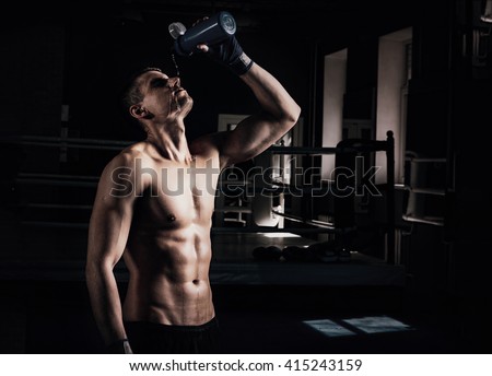Young sporty man in the gym. Male boxer. Training.Mood,break, rest,, motivation, coach,water - sport concept.
