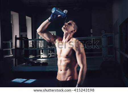 Young sporty man in the gym. Male boxer. Training.Mood,break, rest,, motivation, coach,water - sport concept.