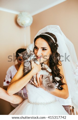 Bridal portrait. Woman preparing for her wedding and her cat