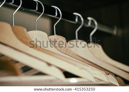 Coat hangers/Several empty coat hangers seen in perspective inside a home closet.