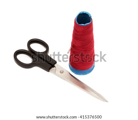 scissors and red thread and needle on white