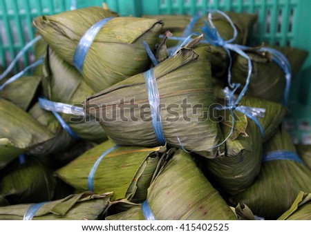Chinese sticky rice dumplings, or zong zi, wrapped in bamboo leaves.  Made of glutinous rice and different fillings and eaten during Chinese Duanwu festival which falls between mid-May and mid-June.