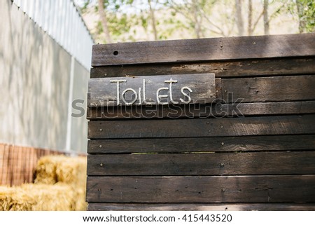 Toilet sign on wooden wall
