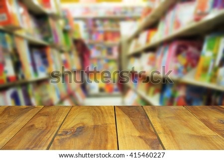 blurred image wood table and abstract book shelf in library as background