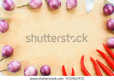 Frame of purple eggplants and chili.