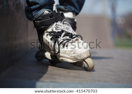Rollerblader wearing professional extreme inline rollerblades made for tricks - grinding and jumping. Dangerous sport popular among youth and teenagers. 