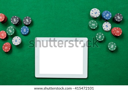 Online poker game with digital tablet and stacks of chips.