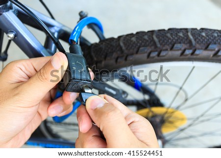 hand holding key to unlocked bicycle Royalty-Free Stock Photo #415524451