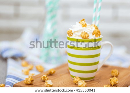Cacao with cream and popcorn on wooden desk