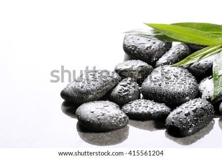  spa basalt stones and green leaves with water drops
