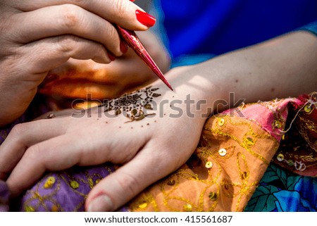 Picture of human hand being decorated with henna Tattoo. mehendi hand