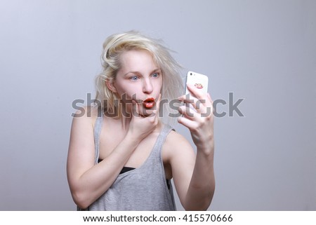 Girl doing selfie, crazy photos. the girl takes pictures of herself in the phone. Life in social networks, narcissism, modern personality. Personality disorder.