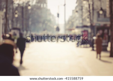 Blurred background. Blurred people walking through a city street. Toned photo.