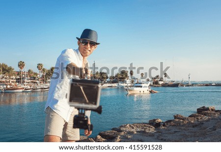 Man with action camera take a selfie photo in the tropical sea bay