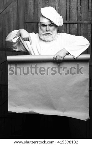 Cook holding parchment paper brown color on wooden background, copy space, , black and white