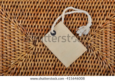 Empty paper tag on wickered wooden background