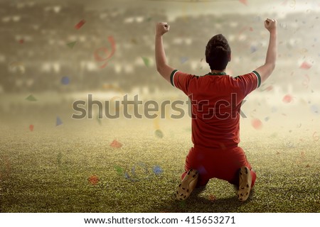 Image of winning football player after score in a match Royalty-Free Stock Photo #415653271