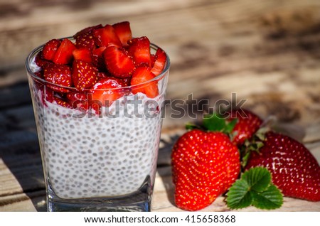 Chia pudding with strawberries on wooden table in Sunny day