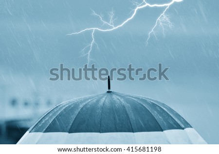 umbrella under the rain with lightning at horizon