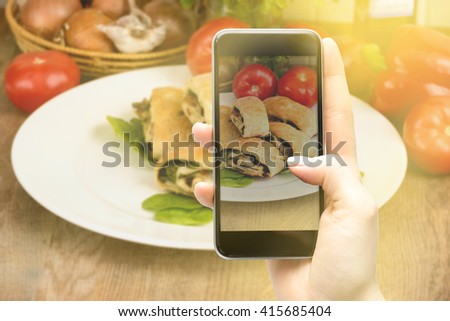 Using a smartphone to take pictures of food.