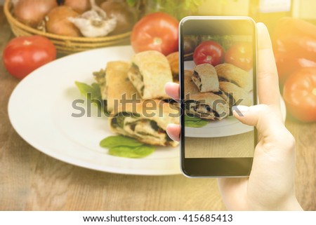 Using a smartphone to take pictures of food.