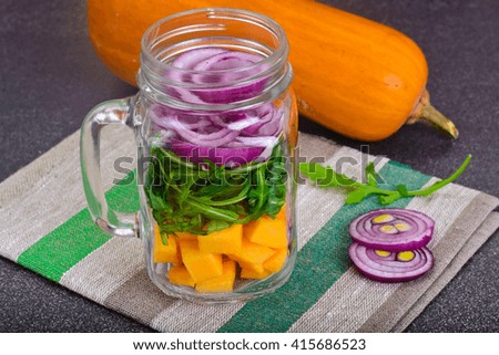 Salad with Pumpkin, Arugula and Red Onion in Glass Jar Studio Photo