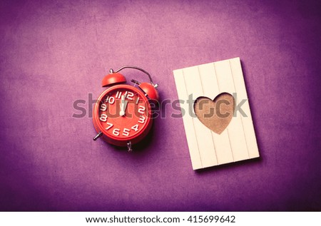 photo of the red clock and postcard on the purple background