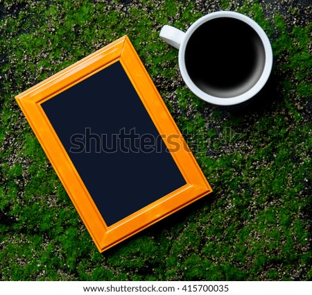 photo frame and cup of coffee on the green background
