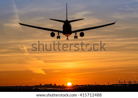 Plane is landing during a nice early morning sunrise.