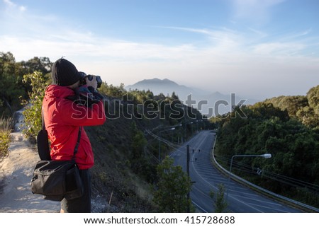Nature photographer with digital camera on the mountain - soft focus