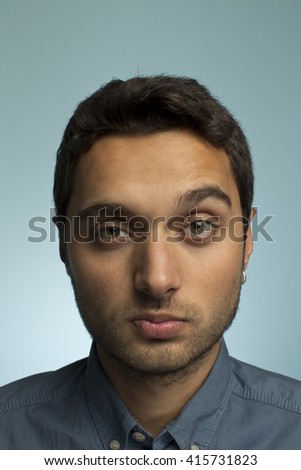 Portrait of a young man making funny face against blue backgroun