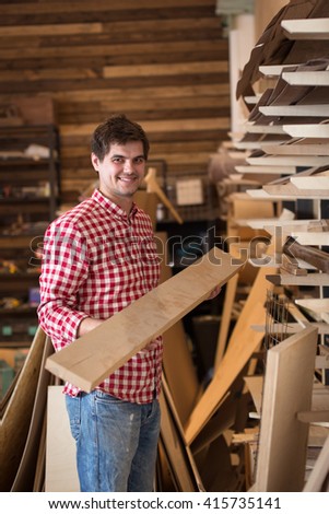 Man carpenter  choosing and buying construction wood in a DIY store chooses  wooden board, joiner's shop, the concept of a hobby, handmade